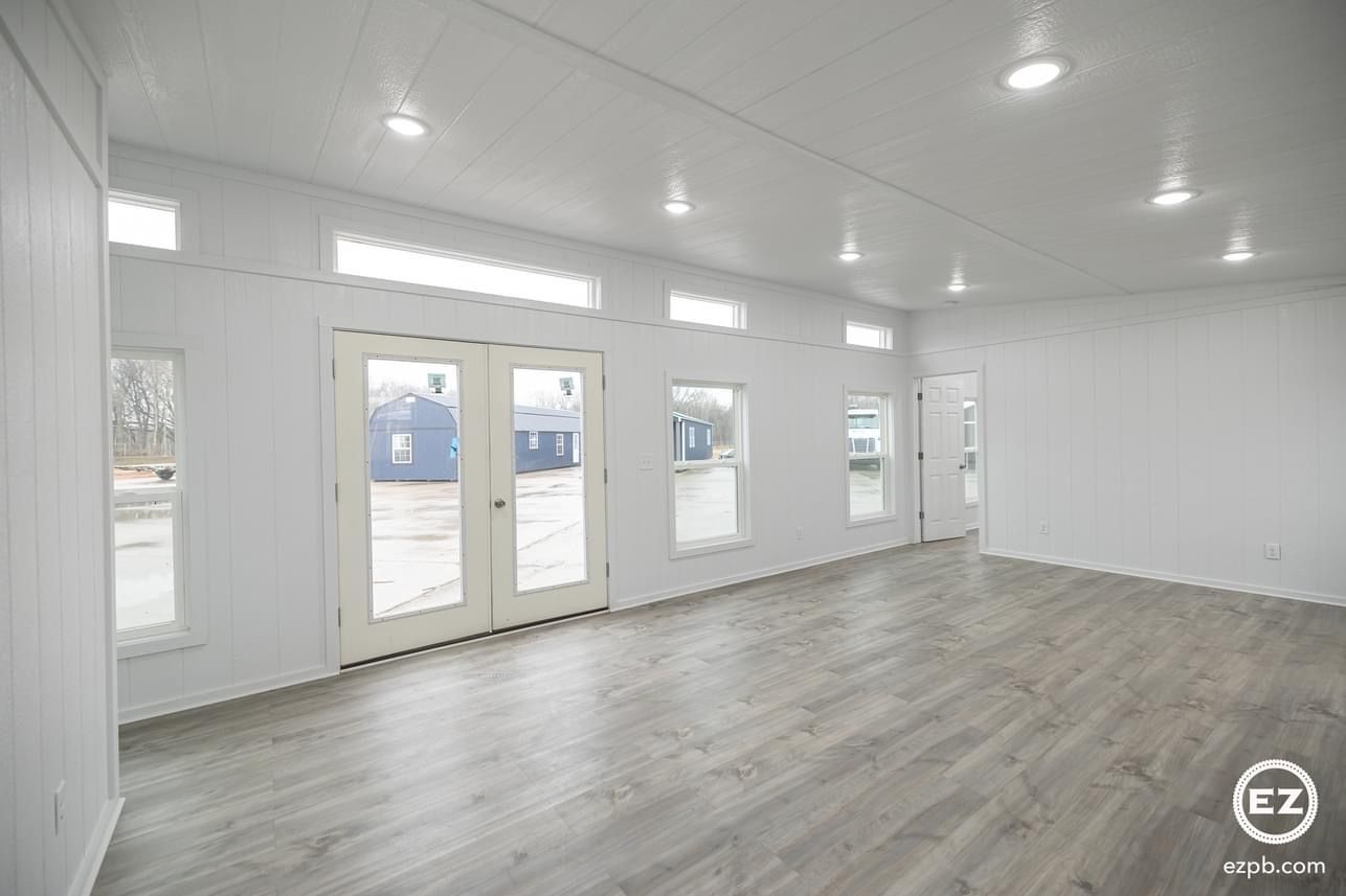 A large empty room with hardwood floors and white walls.