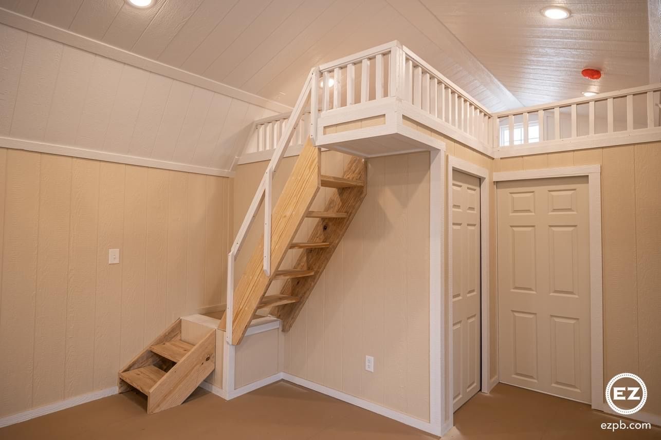 A room with stairs leading up to a loft.