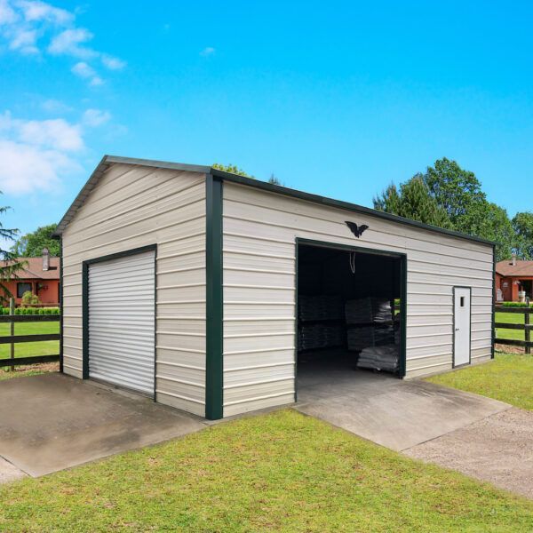 A white garage with a green trim is sitting on top of a lush green field.