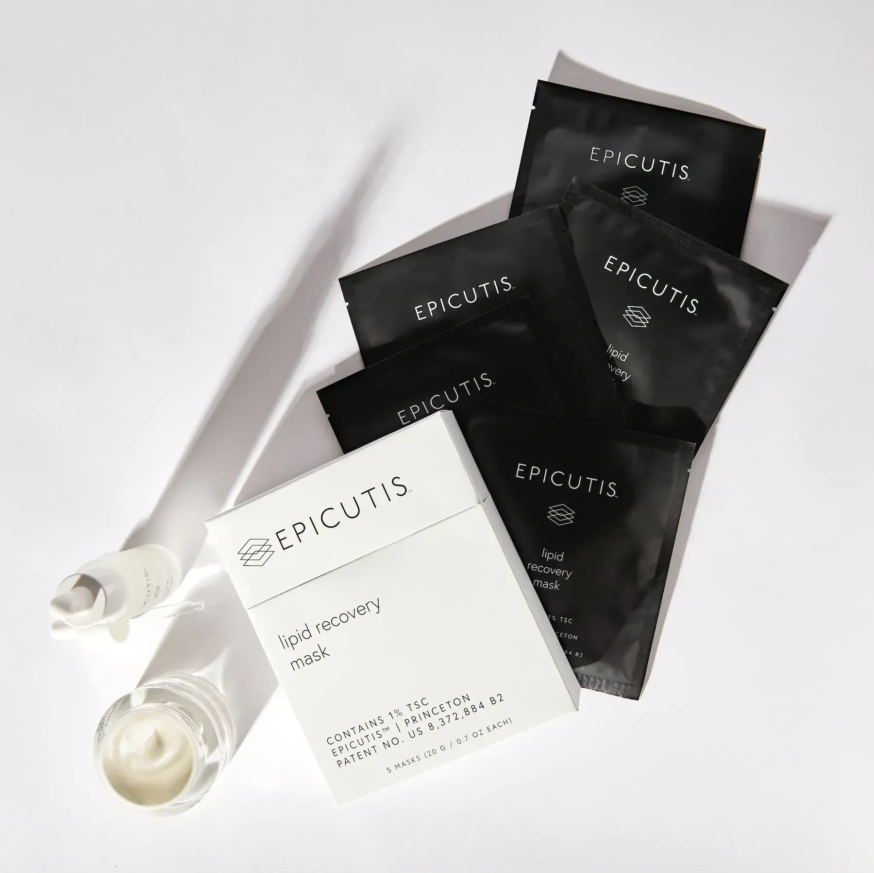 White skincare tubes and black EFCUTIS sachets arranged on a light background