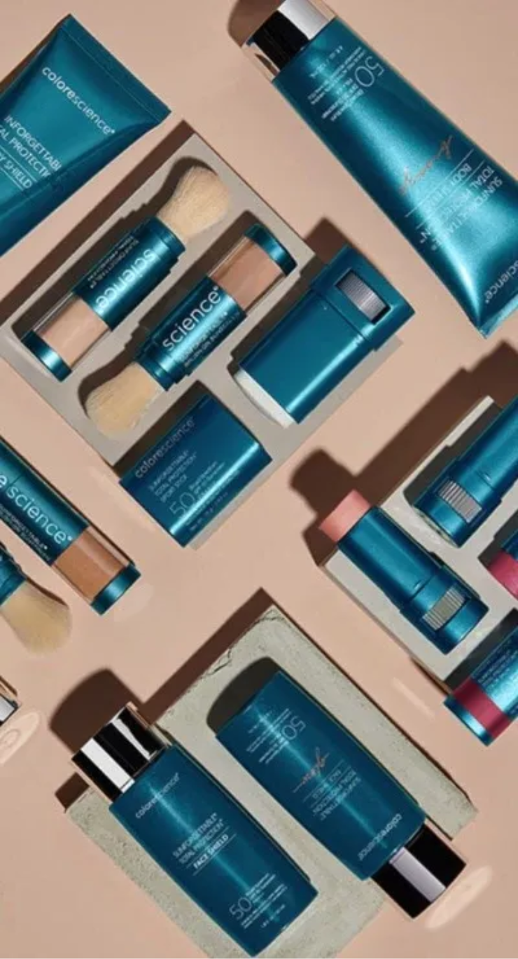 Teal skincare product set in a box, including tubes, bottles, and jars on a beige background