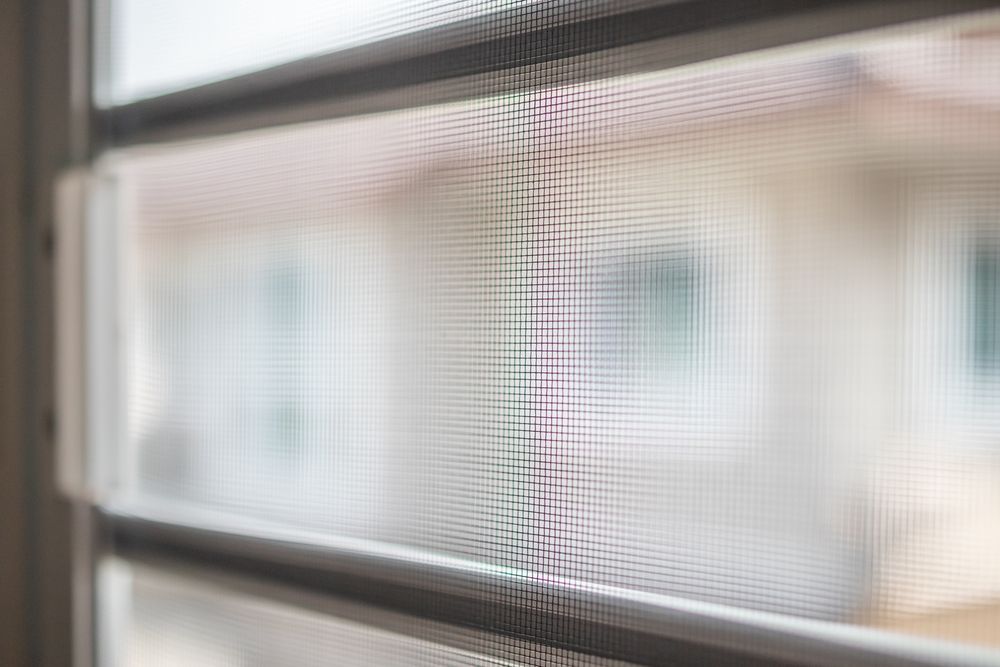 Blurry View Through a Window Screen with A House Visible Outside — Fineworx Joinery in Warnervale, NSW