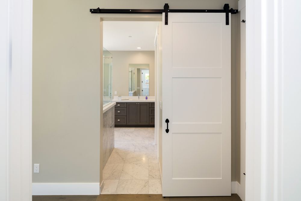 Open White Sliding Barn Door to A Bright Bathroom with Double Vanity and Mirror — Fineworx Joinery in Warnervale, NSW