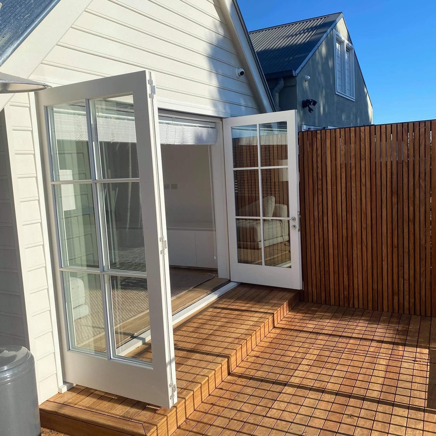 Open White French Doors Leading to A Sunlit Wooden Deck — Fineworx Joinery in Warnervale, NSW