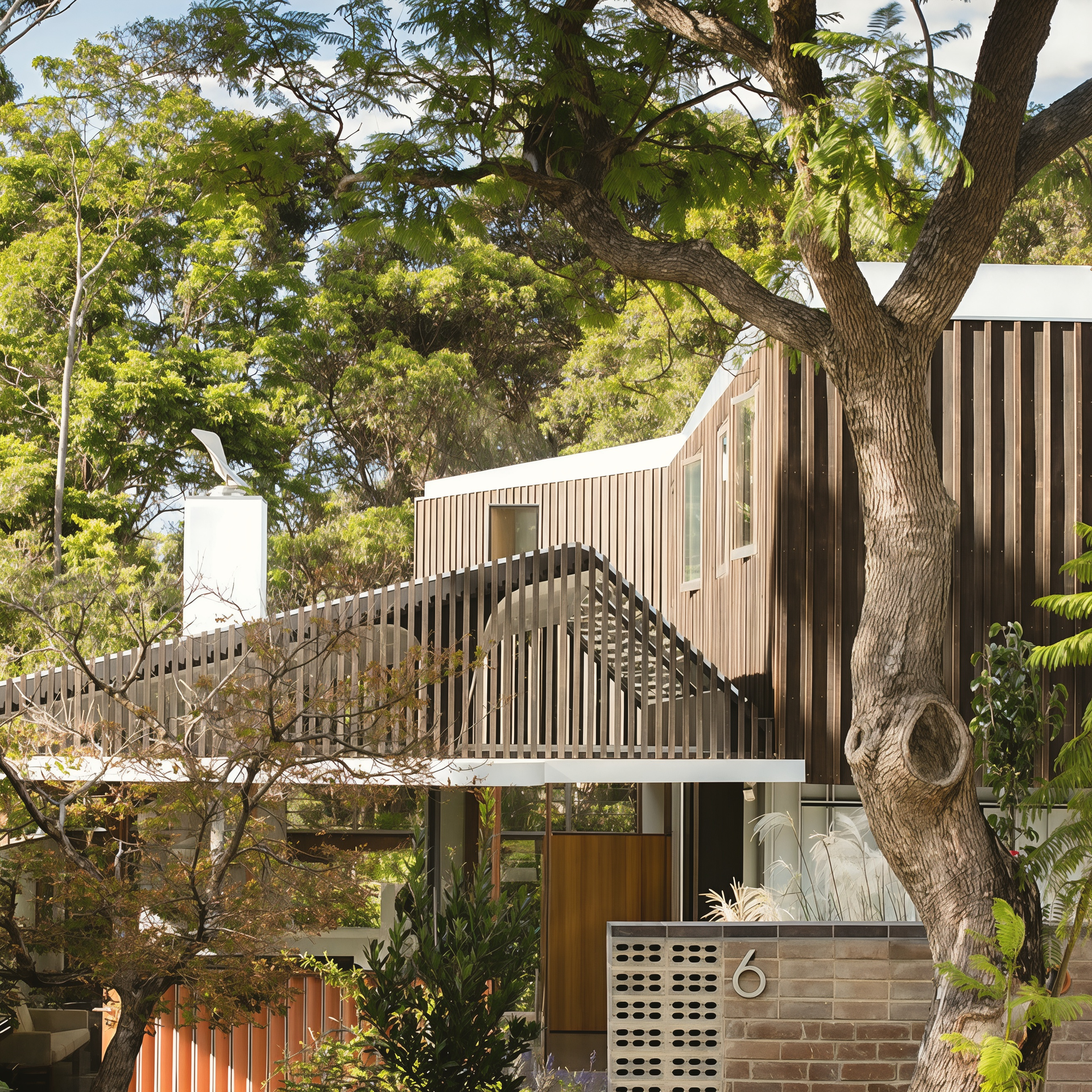 Modern House Facade with Curved Wooden Slats and Large Tree in Front — Fineworx Joinery in Warnervale, NSW