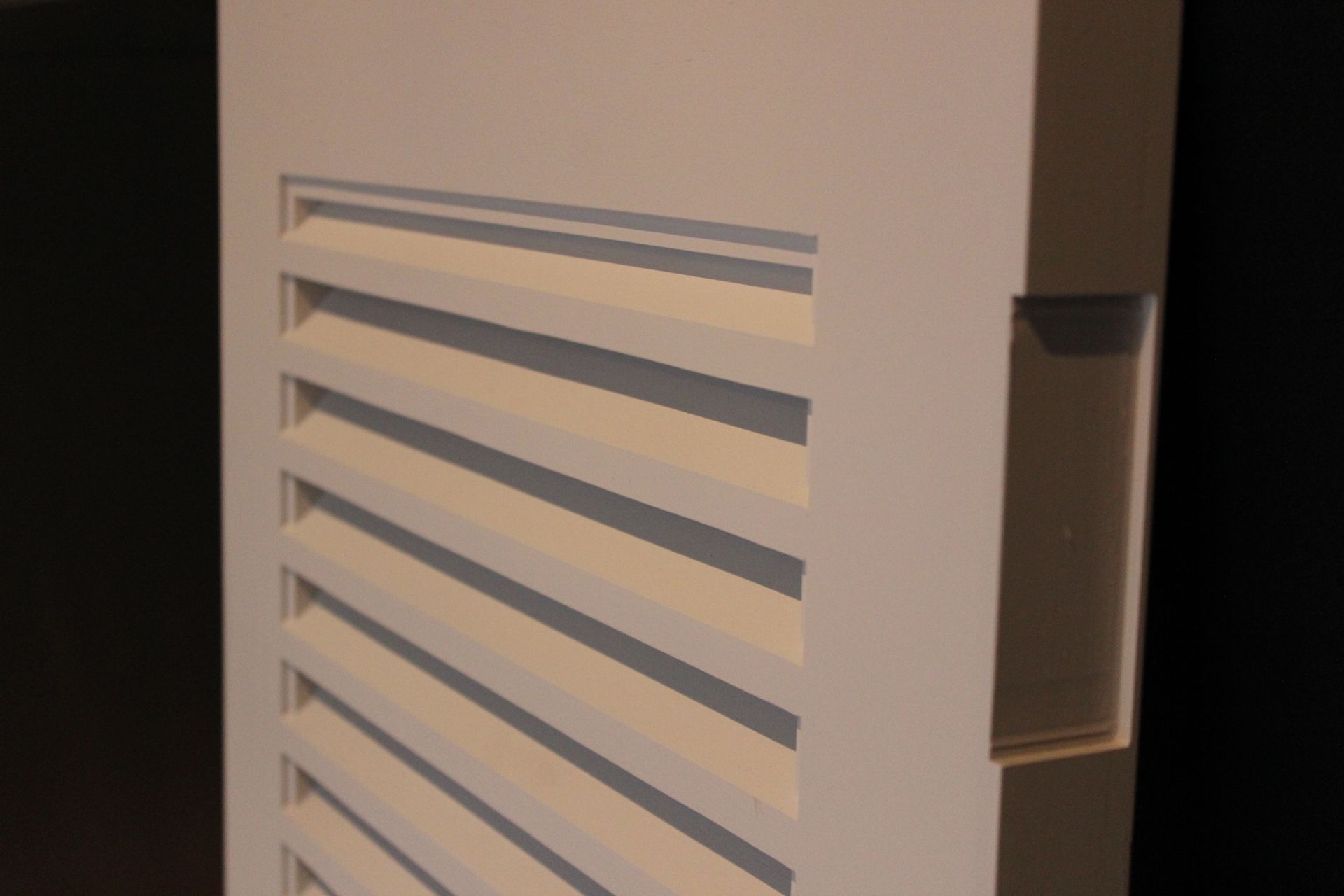 White vented panel on a beige wall with a recessed handle on the right — Fineworx Joinery in Warnervale, NSW