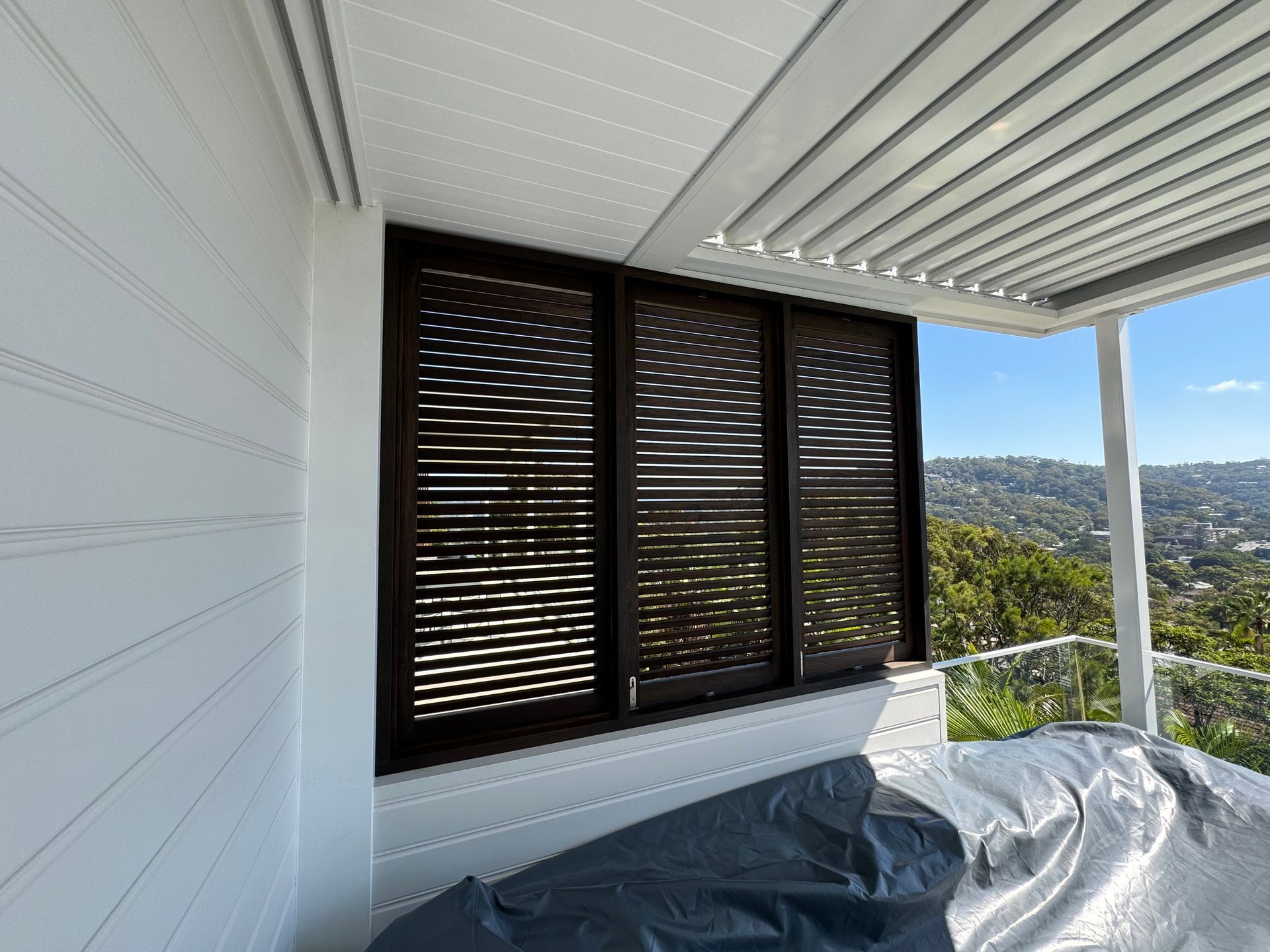 Covered Balcony With White Walls, Dark Shutters, and a View of Hills — Fineworx Joinery in Warnervale, NSW