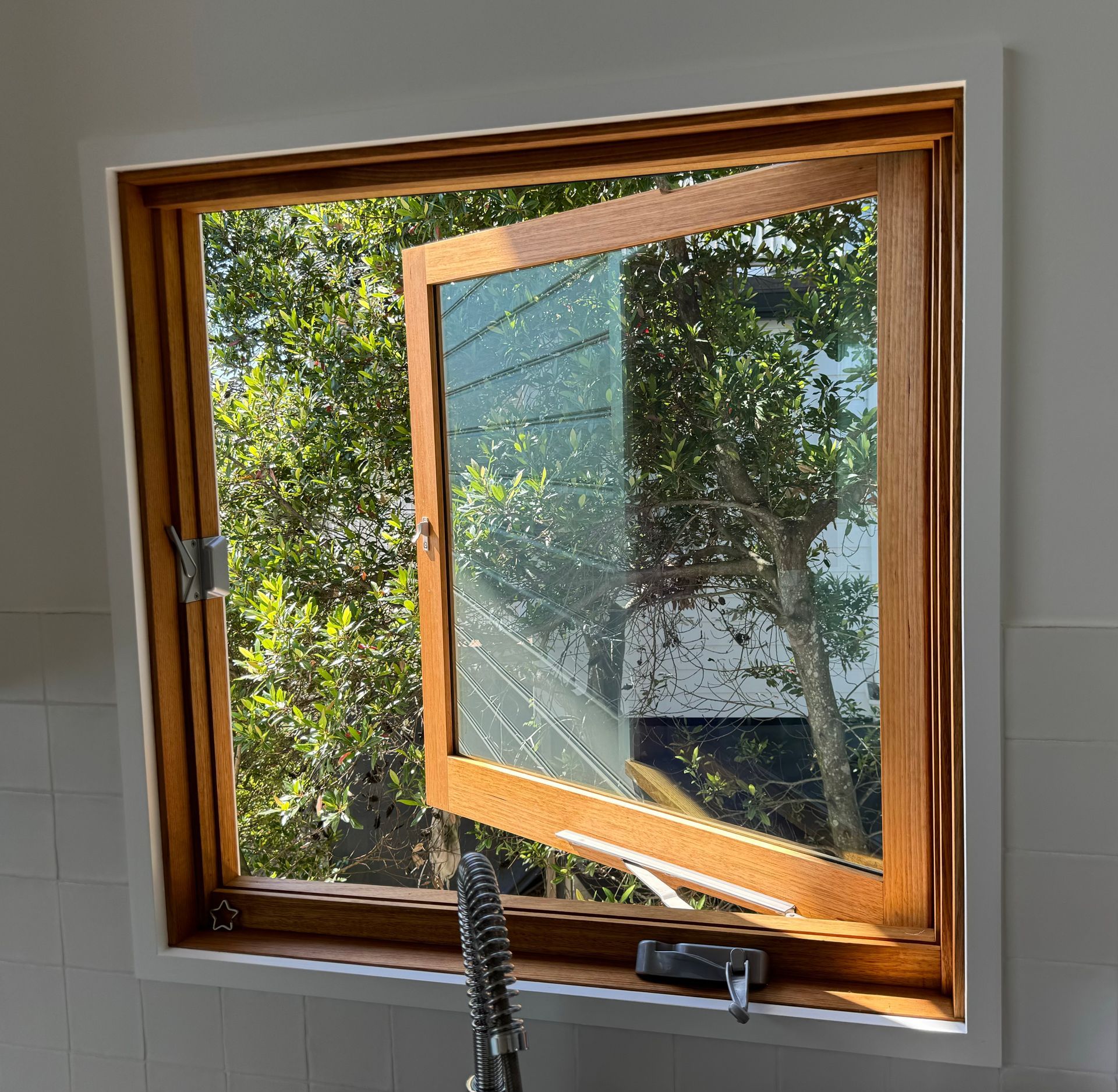 Open Wooden Window Showing Leafy Trees Outside and Bright Sunlight Inside — Fineworx Joinery in Warnervale, NSW