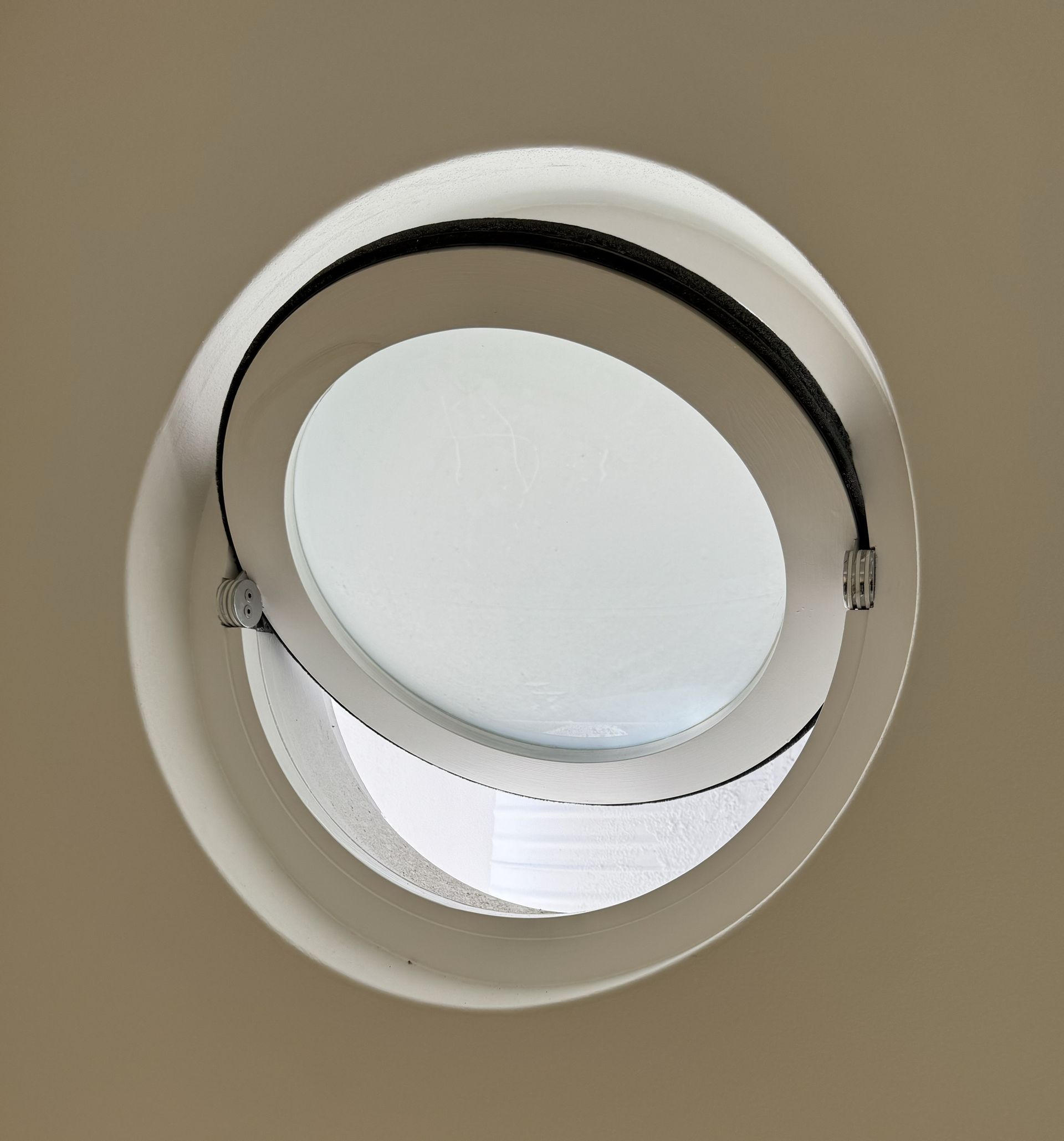 White Ceiling Vent With a Circular Black-edged Flap Against a Beige Wall — Fineworx Joinery in Warnervale, NSW