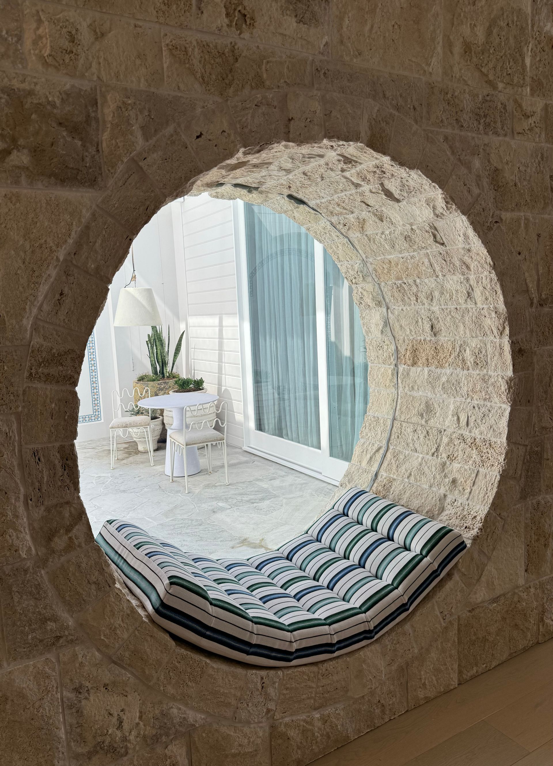 Round Window Seat With Striped Cushion Overlooking a Bright White Patio — Fineworx Joinery in Warnervale, NSW