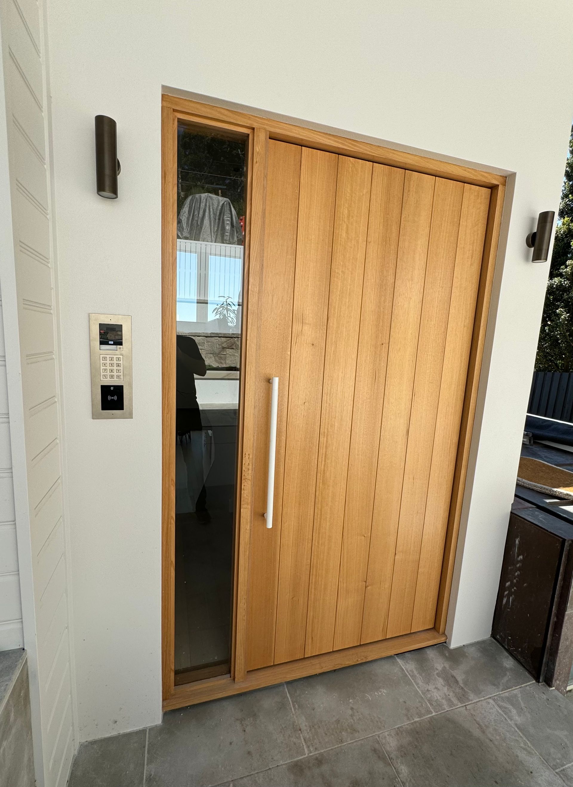 Partially Open Wooden Front Door in a Modern Entryway With Gray Tile Flooring — Fineworx Joinery in Warnervale, NSW