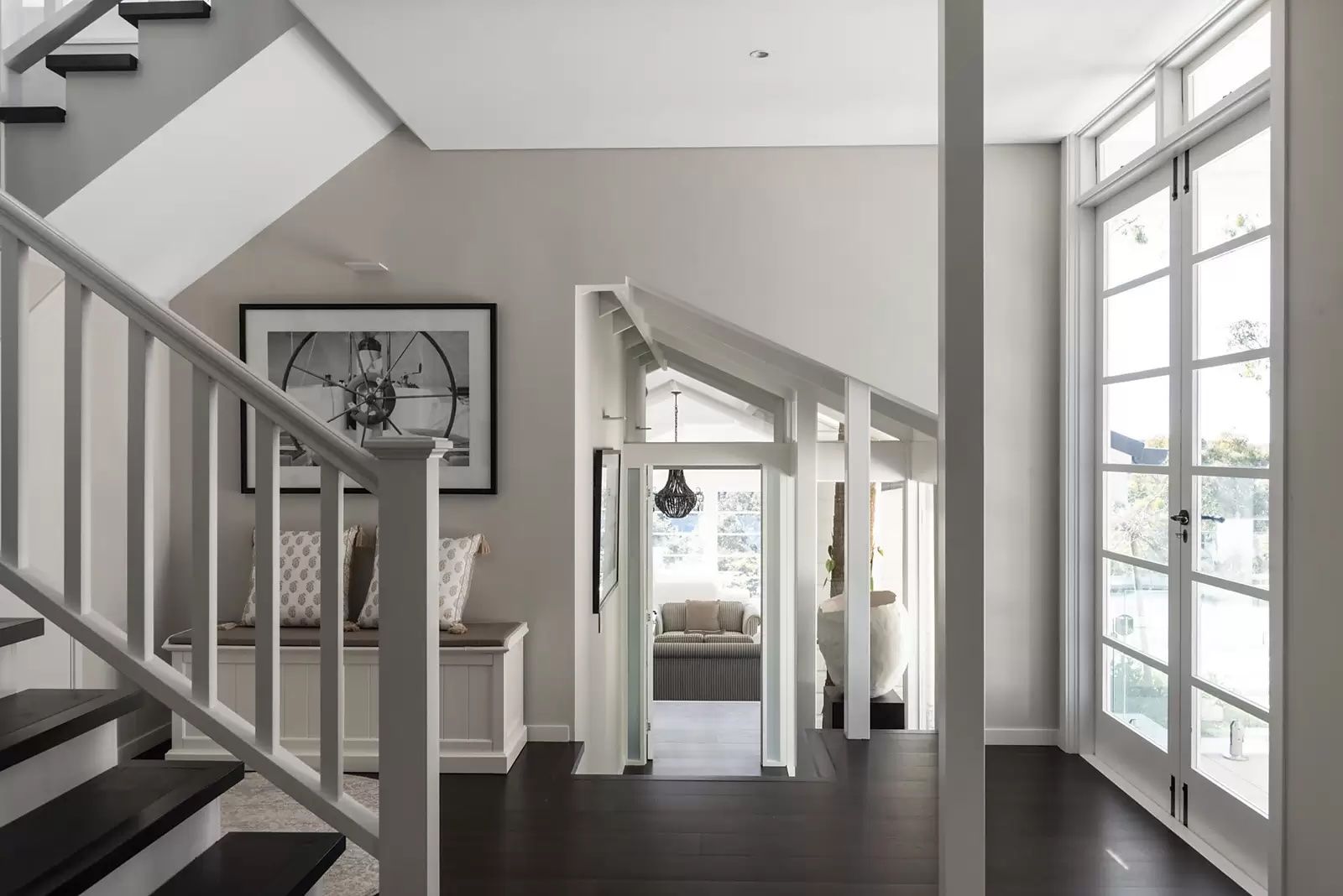 Bright modern foyer with staircase, framed art, and large windows overlooking water — Fineworx Joinery in Warnervale, NSW
