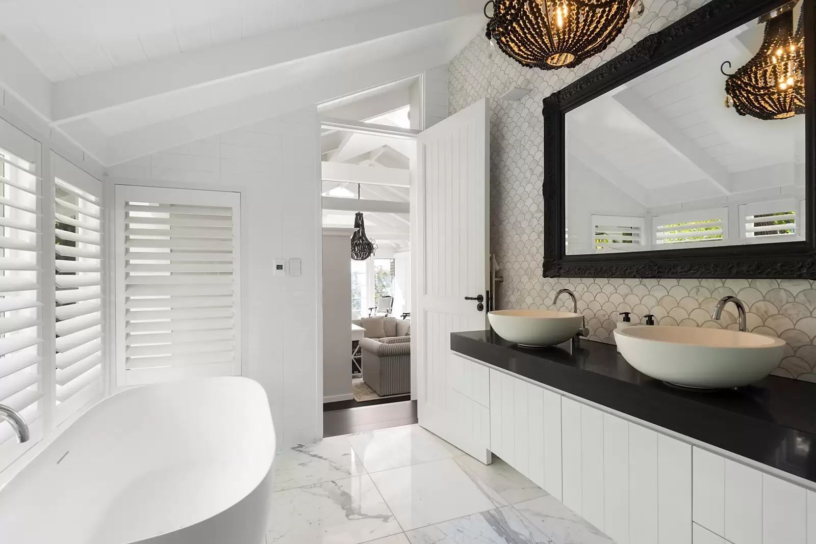 Bright modern bathroom with white tub, double sinks, black vanity, and large mirror — Fineworx Joinery in Warnervale, NSW