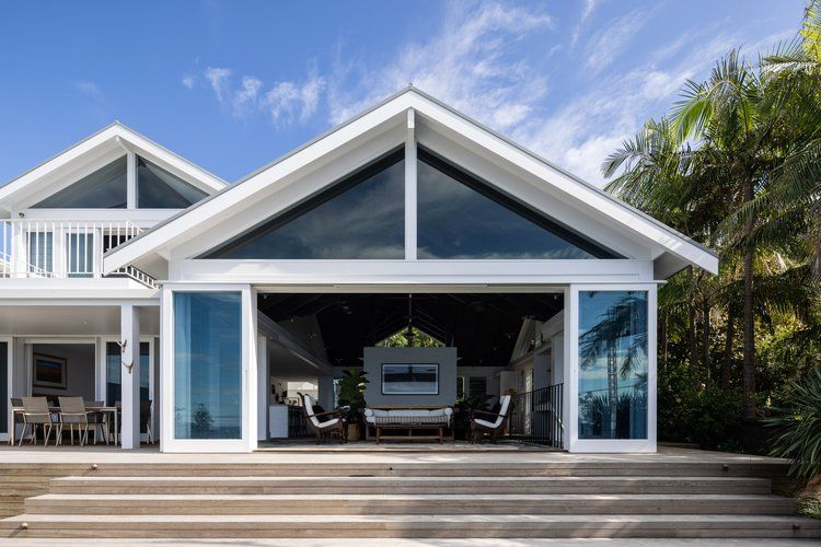 Modern beachfront house with a large open patio, white trim, and blue glass under a bright sky — Fineworx Joinery in Warnervale, NSW