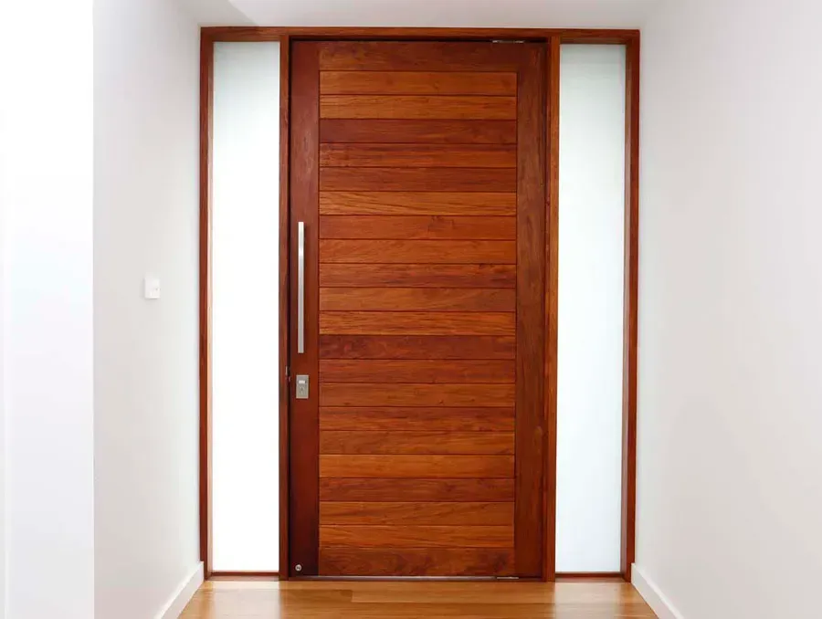Modern wooden front door with sidelights in a white hallway — Fineworx Joinery in Warnervale, NSW