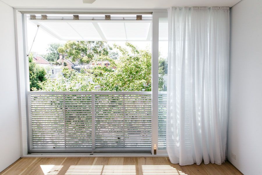 Bright empty room with floor-to-ceiling window, sheer curtains, and balcony view of greenery — Fineworx Joinery in Warnervale, NSW