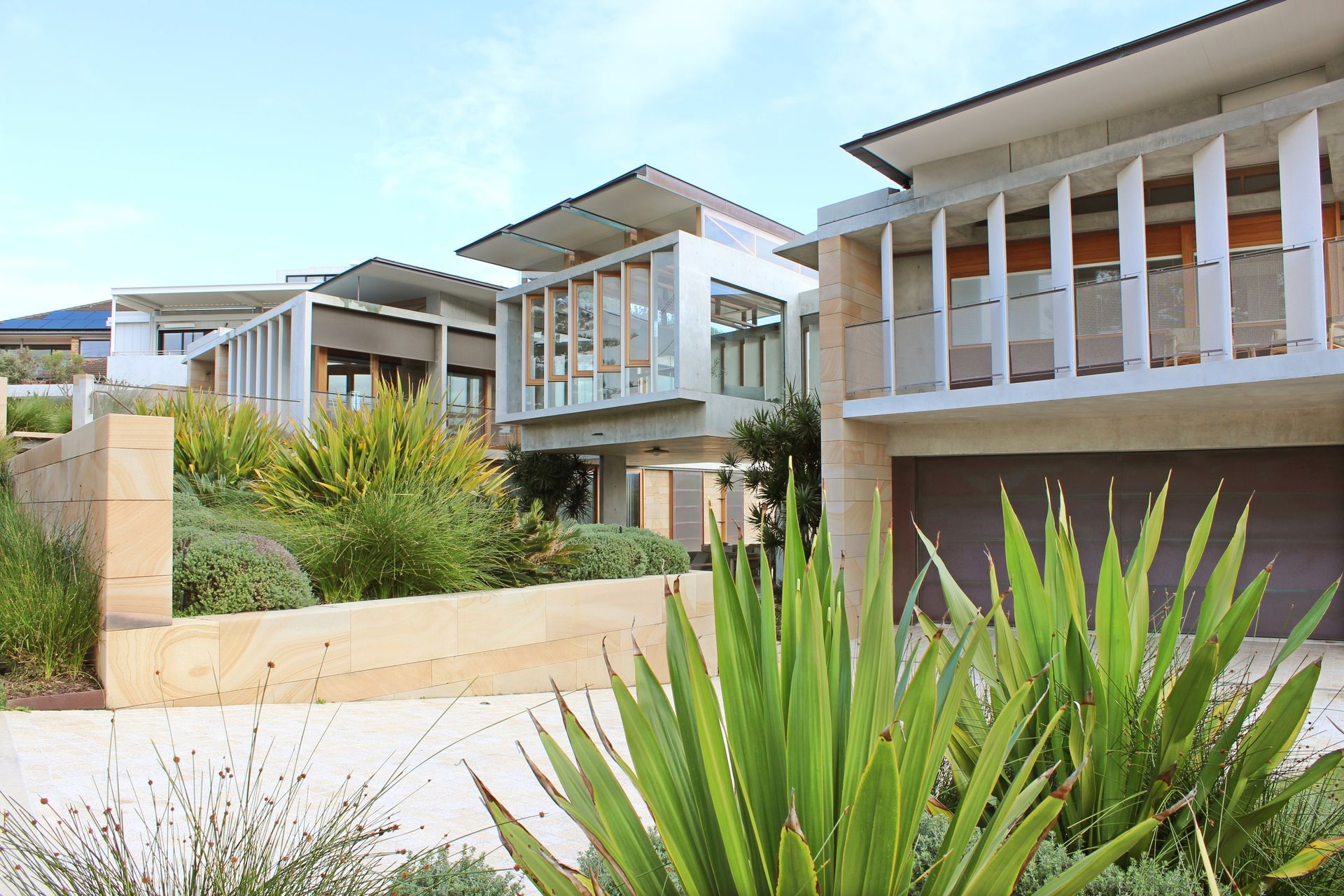 Modern Apartment Buildings With Balconies and Lush Landscaping — Fineworx Joinery in Warnervale, NSW