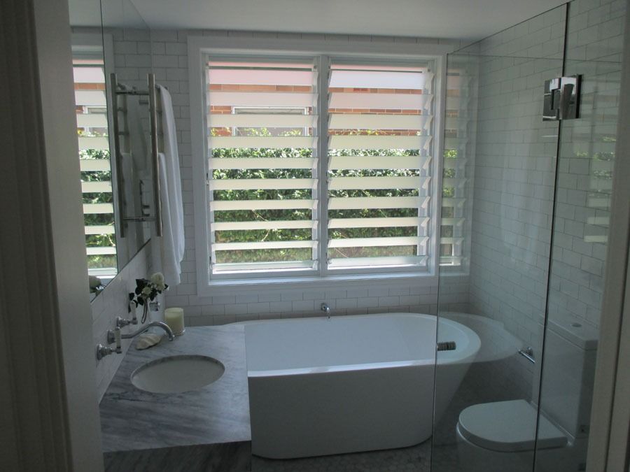 Bright Modern Bathroom with A Freestanding Tub and Large Window with Blinds — Fineworx Joinery in Warnervale, NSW
