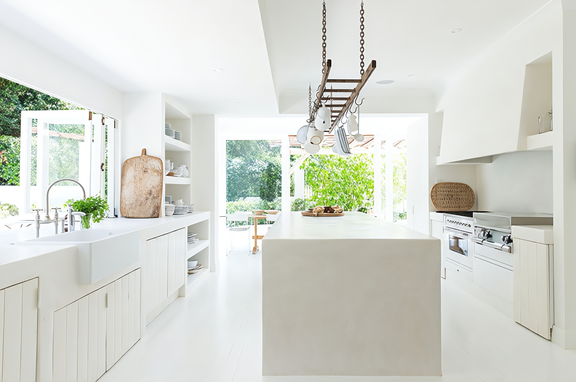 Bright white modern kitchen with central island, skylight, and large windows overlooking greenery. — Fineworx Joinery in Warnervale, NSW