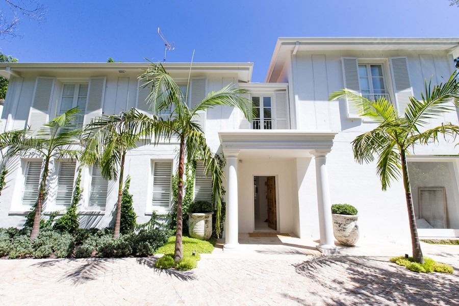 Bright White Modern Villa with Palm Trees and A Central Covered Entrance — Fineworx Joinery in Warnervale, NSW