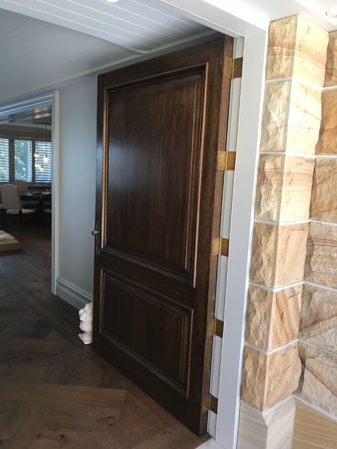 Dark Wood Double Doors in A Home Entryway Beside a Stone Column — Fineworx Joinery in Warnervale, NSW