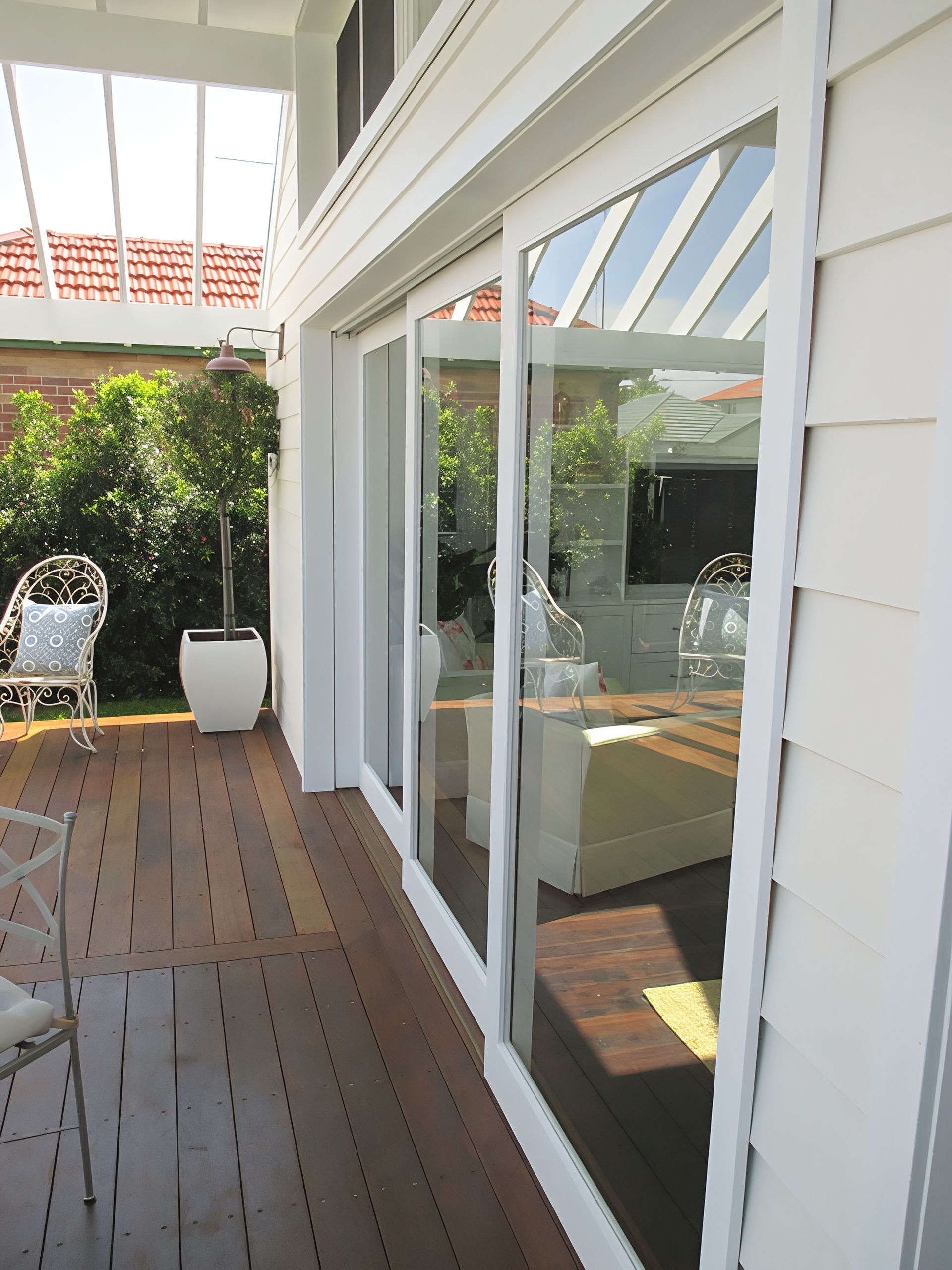 Covered Patio with Sliding Glass Doors and White Planter by A Hedge — Fineworx Joinery in Warnervale, NSW