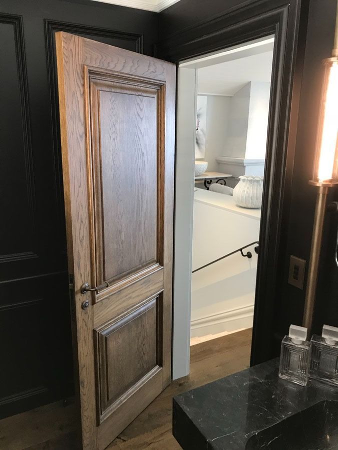 Open Wooden Door to A Bright White Bathroom with Black Countertop — Fineworx Joinery in Warnervale, NSW