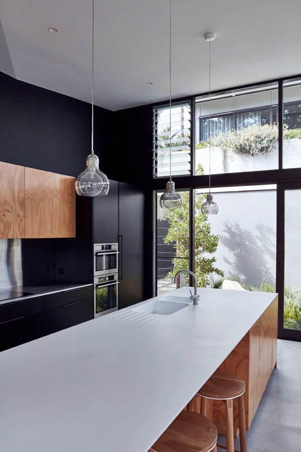 Modern Kitchen with A Large White Island, Black Cabinetry and Tall Glass Doors — Fineworx Joinery in Warnervale, NSW