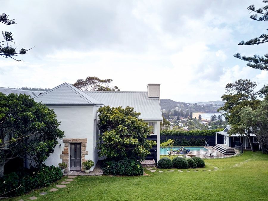 White House with A Gray Roof and Lush Green Garden Overlooking a Distant Landscape — Fineworx Joinery in Warnervale, NSW