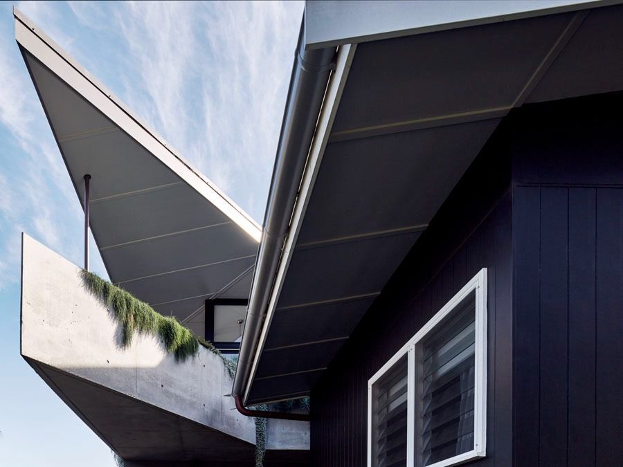 Modern House Exterior with Angular Roofs and White Trimmed Windows — Fineworx Joinery in Warnervale, NSW