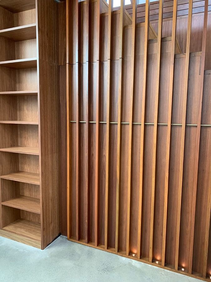 Wooden Slatted Wall Beside an Empty Built In Bookshelf in A Modern Room — Fineworx Joinery in Warnervale, NSW