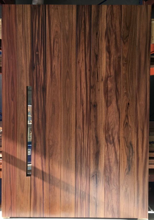 Wood Grain Wooden Door with A Vertical Metal Handle on The Left Side — Fineworx Joinery in Warnervale, NSW