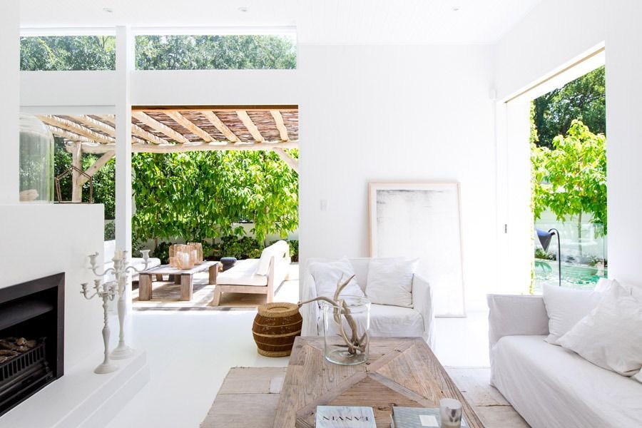 Bright White Living Room Opening to A Leafy Patio with A Fireplace — Fineworx Joinery in Warnervale, NSW