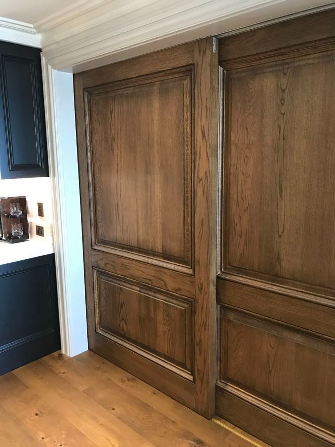 Wood Paneled Kitchen Cabinet Doors Beside a Dark Countertop and Wood Floor — Fineworx Joinery in Warnervale, NSW