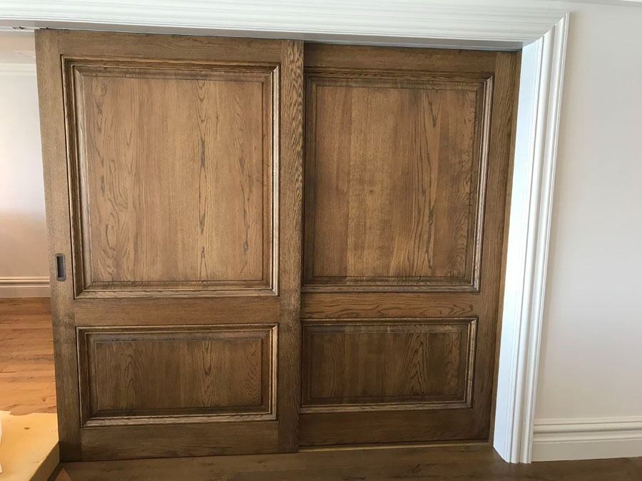 Wooden Double Doors with Raised Panels in A Light Colored Interior Hallway — Fineworx Joinery in Warnervale, NSW