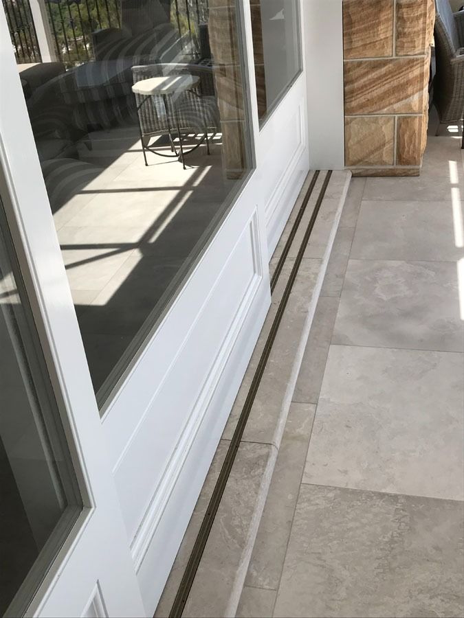 White Sliding Glass Door Opening to A Patio with Tiled Floor — Fineworx Joinery in Warnervale, NSW