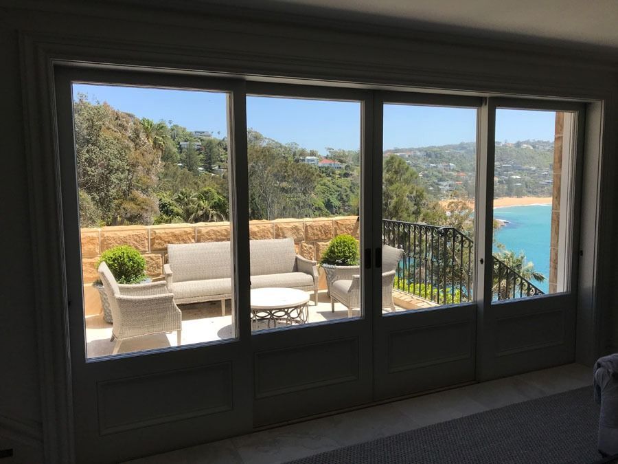 Patio with White Seating and View of Blue Ocean Through Large Windows — Fineworx Joinery in Warnervale, NSW