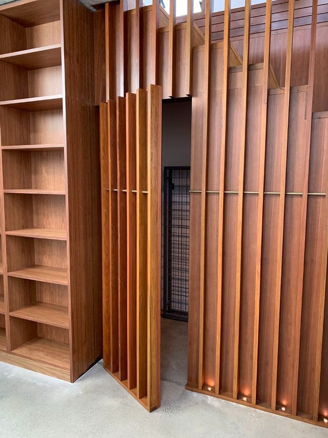 Wood Paneled Doorway with Vertical Slats and Built In Wooden Shelving — Fineworx Joinery in Warnervale, NSW