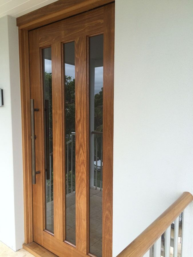 Wooden Front Door with Glass Panels Beside a White Wall and Staircase Railing — Fineworx Joinery in Warnervale, NSW