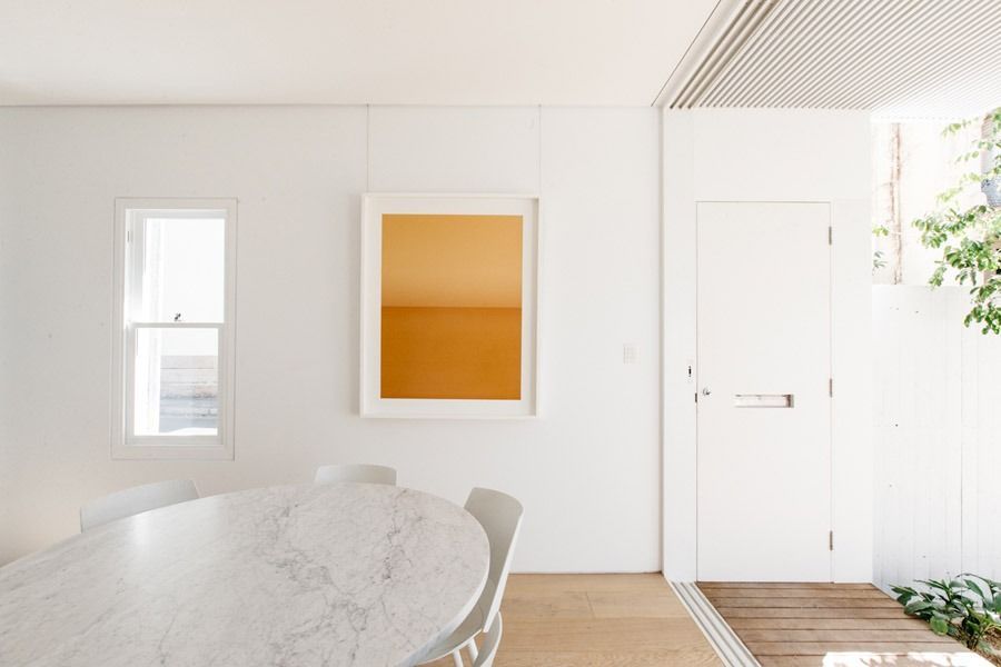 Minimal White Dining Room with Oval Marble Table and A Door by A Sunlit Window — Fineworx Joinery in Warnervale, NSW