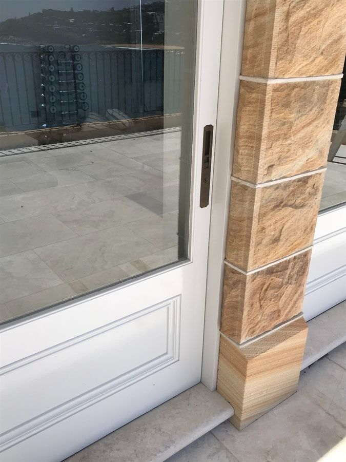 Glass Storefront Door Beside Tan Stone Wall and White Frame — Fineworx Joinery in Warnervale, NSW
