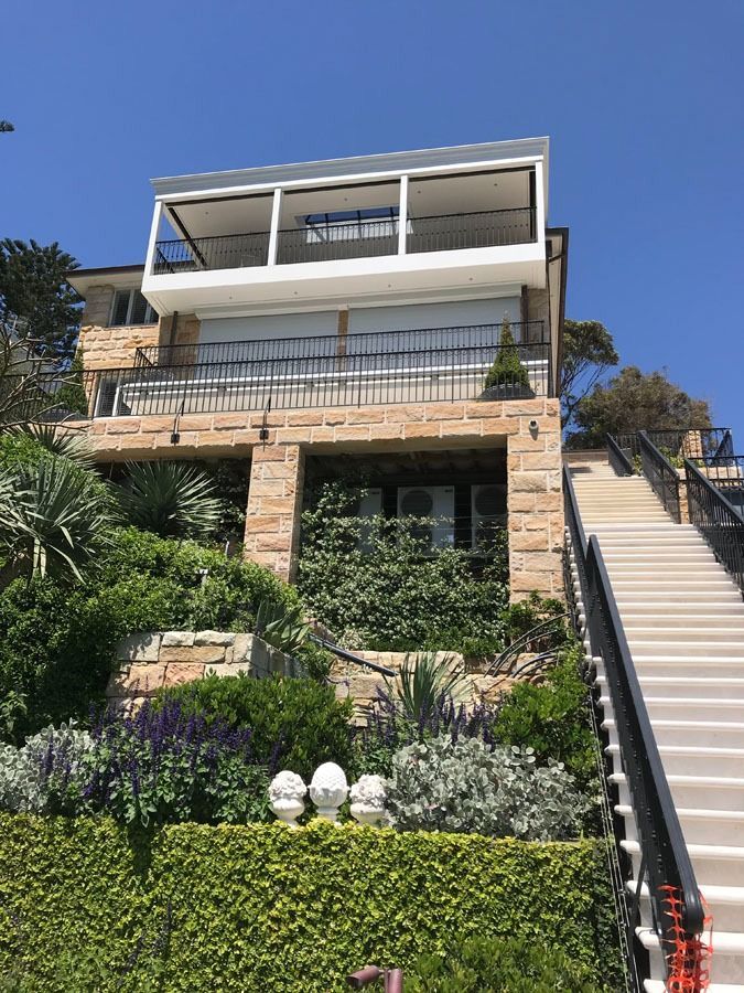 Multi Story Hillside House with Stone Facade, Greenery and A Staircase  — Fineworx Joinery in Warnervale, NSW