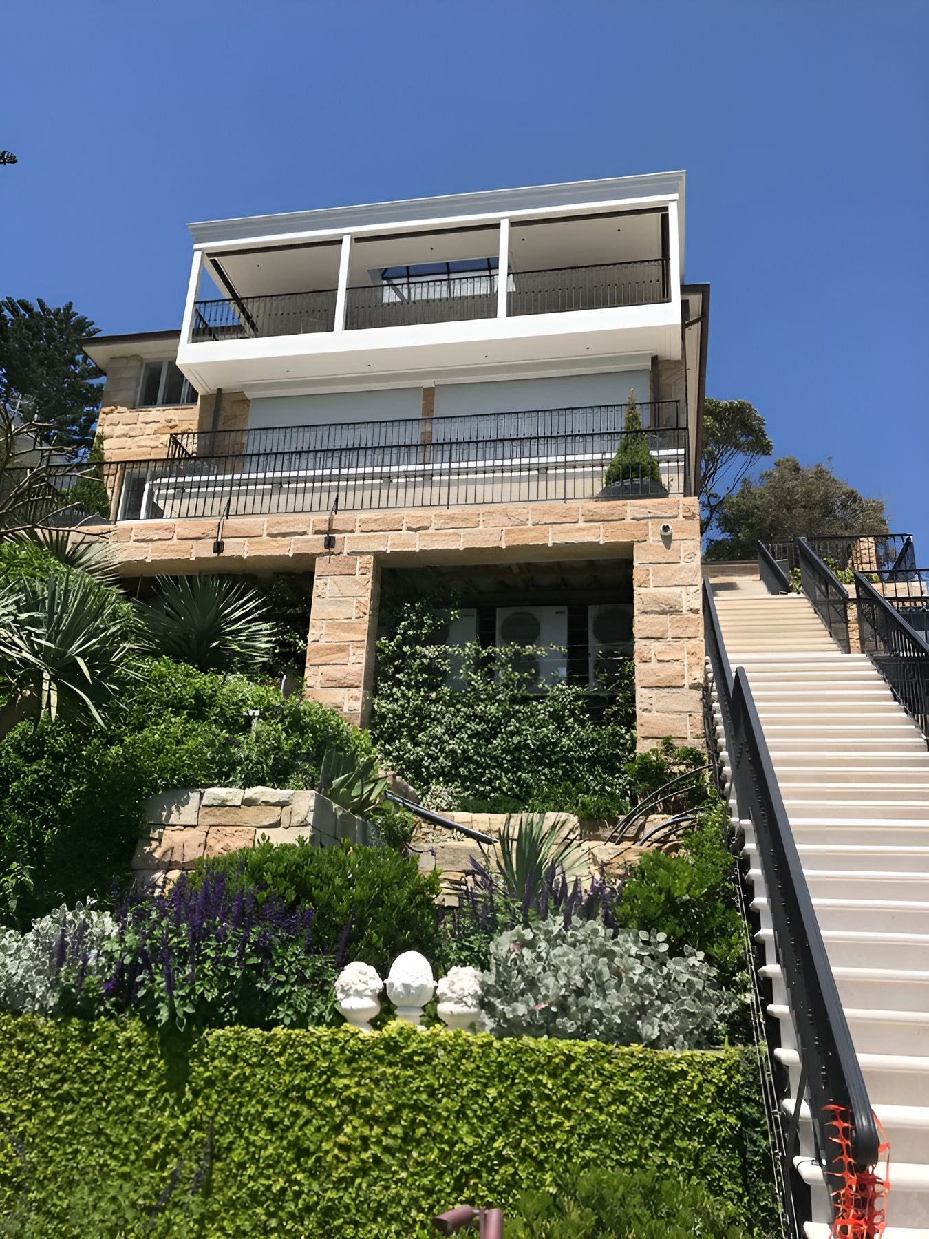 Modern Hillside House with Stone Facade and White Balconies — Fineworx Joinery in Port Stephens, NSW