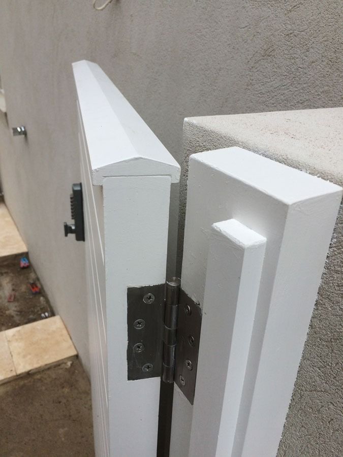 Close Up of A White Gate Hinge Connecting Two Posts Beside a Wall — Fineworx Joinery in Warnervale, NSW