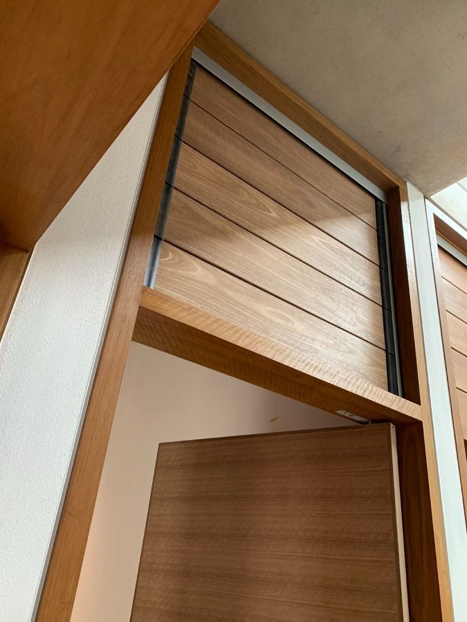 Wooden Closet with A Tilted Louvered Door Partly Open in A Hallway — Fineworx Joinery in Warnervale, NSW