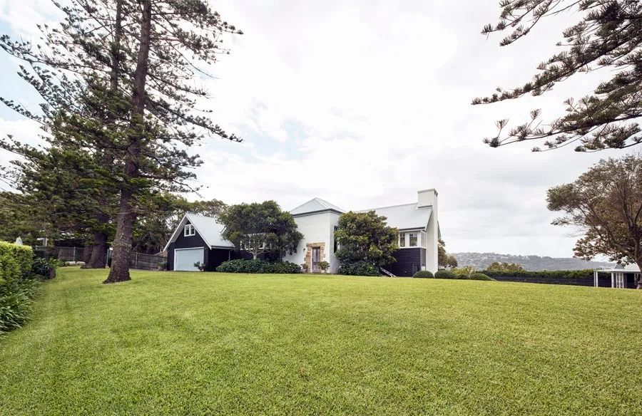 Wide Green Lawn with A White House and Tall Trees Under a Cloudy Sky — Fineworx Joinery in Warnervale, NSW