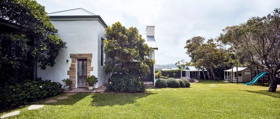White House with Ivy Beside a Green Lawn and Trees — Fineworx Joinery in Warnervale, NSW