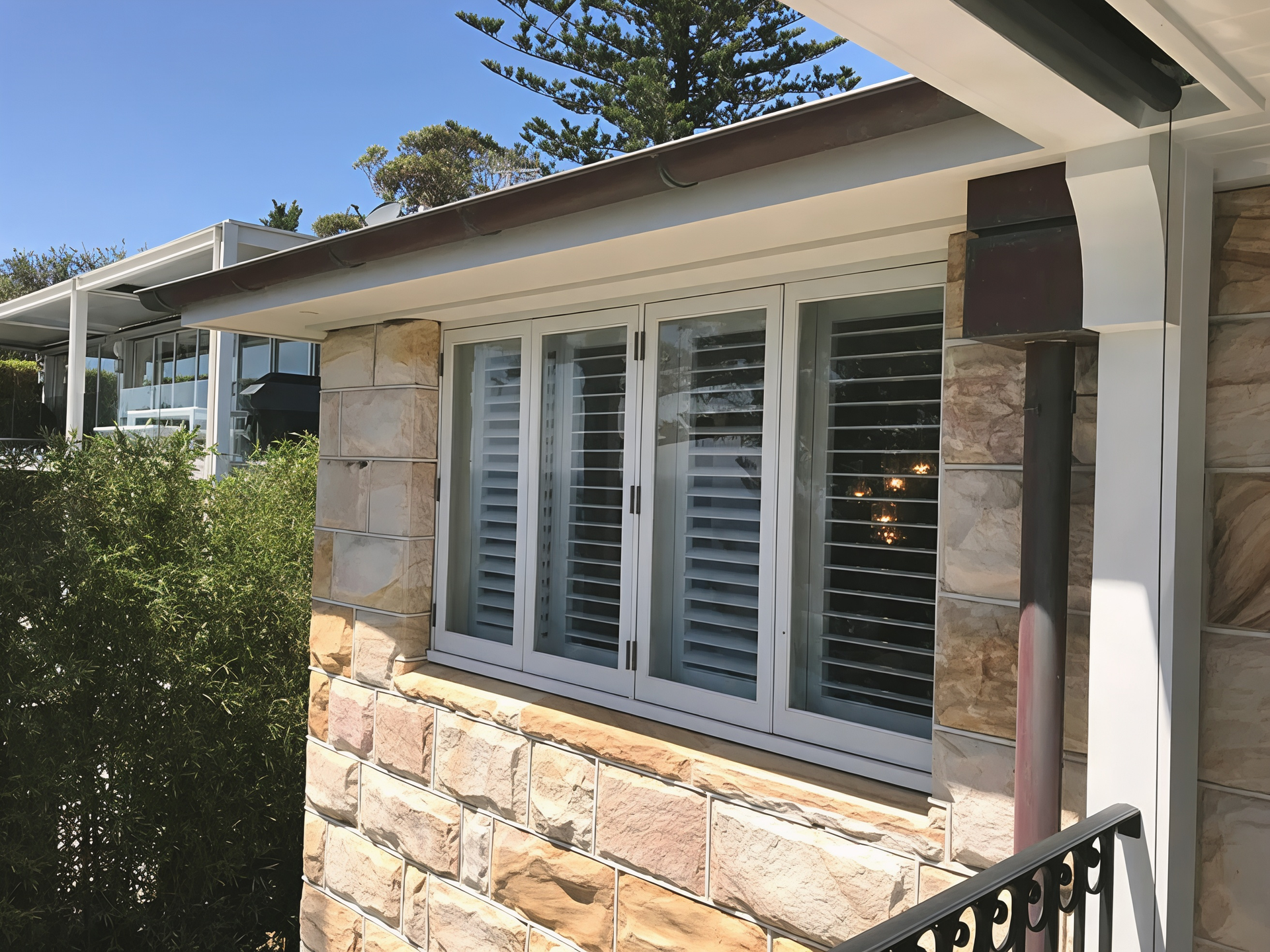 Stone House Exterior with White Framed Windows Shutters and A Small Awning — Fineworx Joinery in Warnervale, NSW