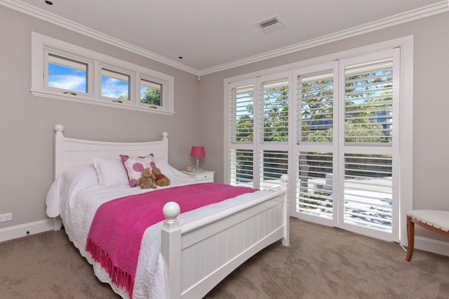 Bright Bedroom with White Bed and Large Windows with Shutters — Fineworx Joinery in Warnervale, NSW