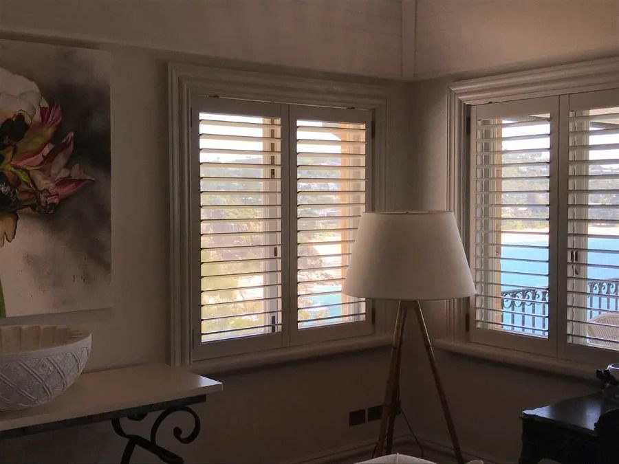 Bright Living Room Corner with White Shutters and A Table by The Window — Fineworx Joinery in Warnervale, NSW